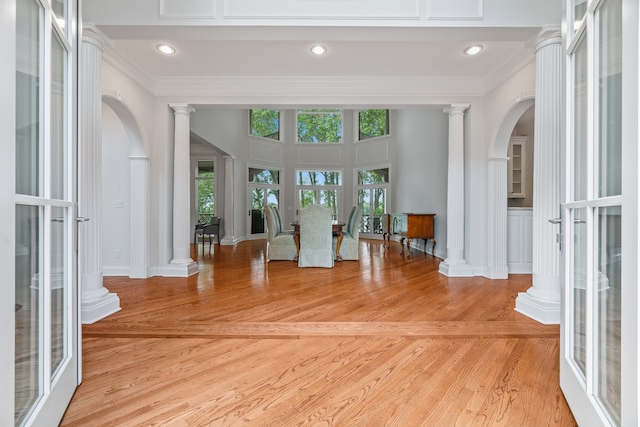 interior space with ornamental molding, hardwood / wood-style flooring, and ornate columns