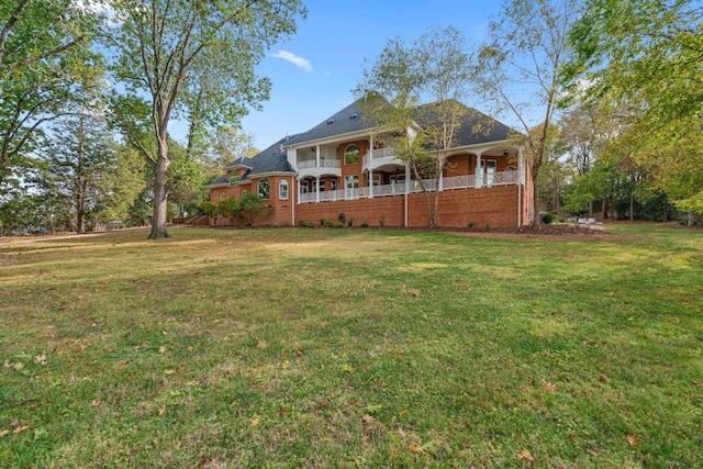 view of front of house with a balcony and a front yard