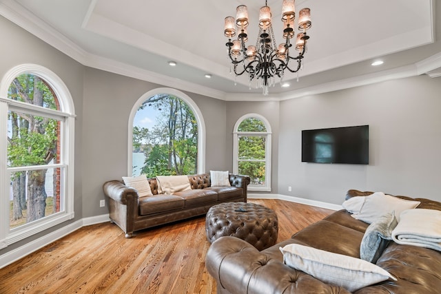 living room with light wood-type flooring, ornamental molding, and a wealth of natural light