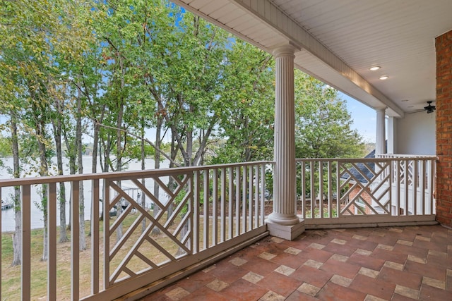 balcony featuring a water view and ceiling fan