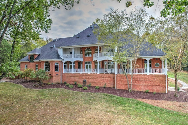 view of front of home featuring a front lawn and a balcony