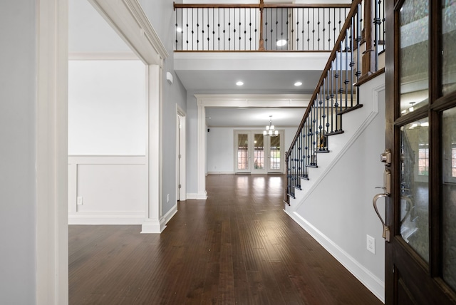 entrance foyer featuring a high ceiling, dark hardwood / wood-style flooring, and a notable chandelier