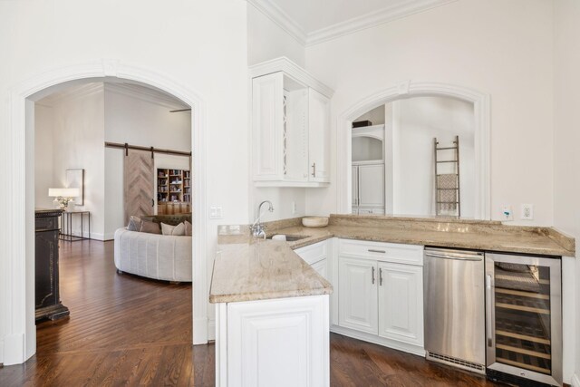 kitchen featuring dark hardwood / wood-style floors, beverage cooler, sink, white cabinetry, and a barn door