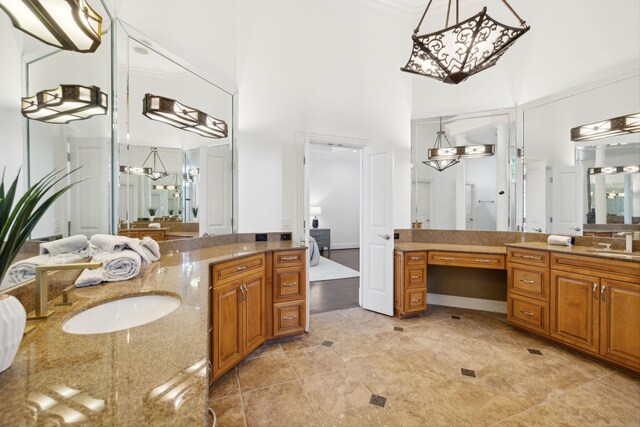 bathroom with ornamental molding, vanity, and a towering ceiling