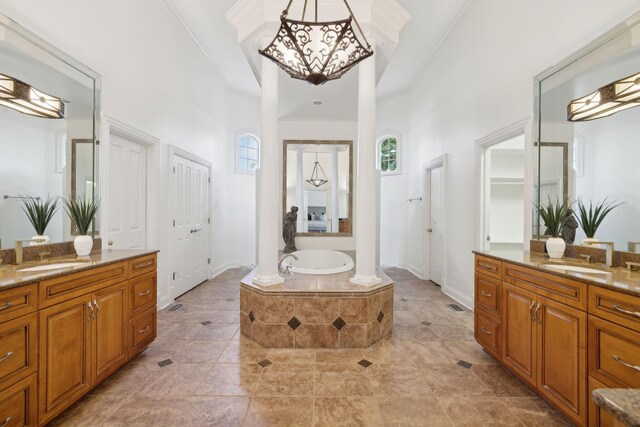 bathroom featuring a towering ceiling, a relaxing tiled tub, ornamental molding, and vanity