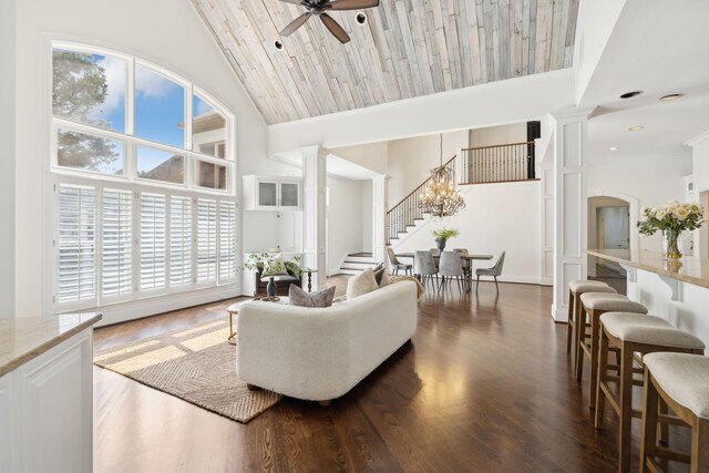 living room featuring ceiling fan with notable chandelier, wood ceiling, ornate columns, dark hardwood / wood-style floors, and high vaulted ceiling