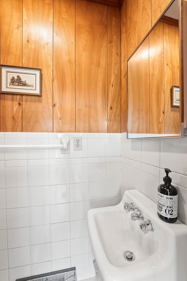 bathroom featuring tile walls and sink