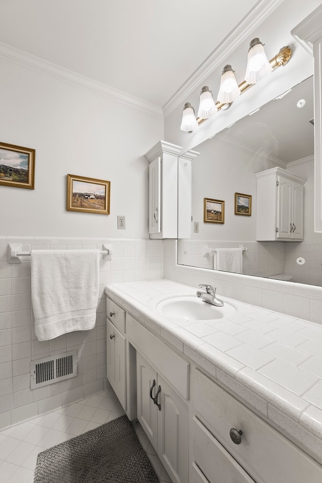 bathroom featuring tile patterned flooring, vanity, ornamental molding, and tile walls