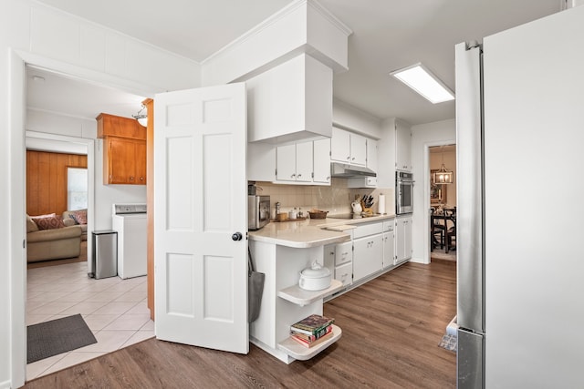 kitchen with washer / clothes dryer, white cabinets, stainless steel appliances, and light hardwood / wood-style flooring