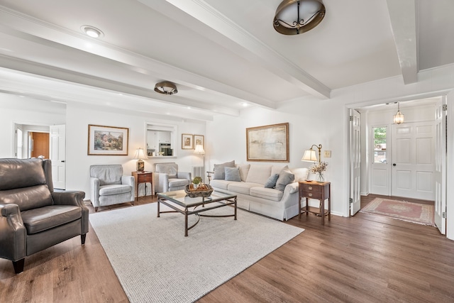 living room featuring dark hardwood / wood-style floors, beamed ceiling, and ornamental molding