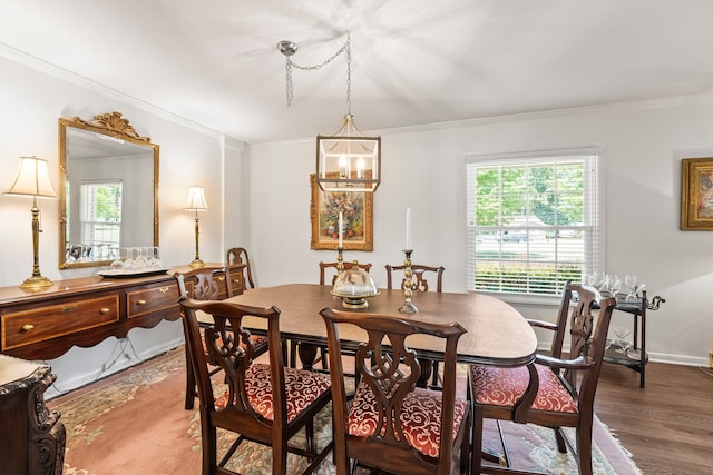 dining area featuring ornamental molding, an inviting chandelier, and hardwood / wood-style floors