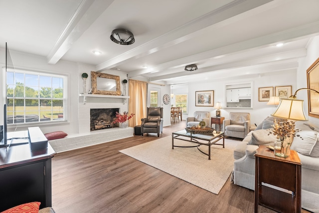 living room featuring a fireplace, dark wood-type flooring, and beamed ceiling