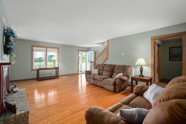 living room with a healthy amount of sunlight, light wood-type flooring, and a fireplace