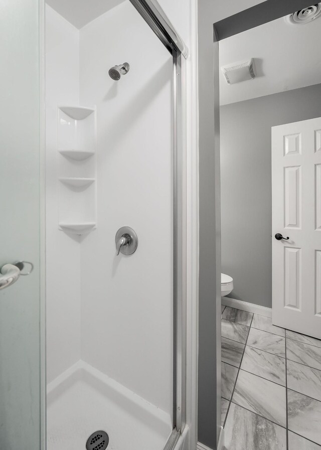 bathroom with toilet and an enclosed shower