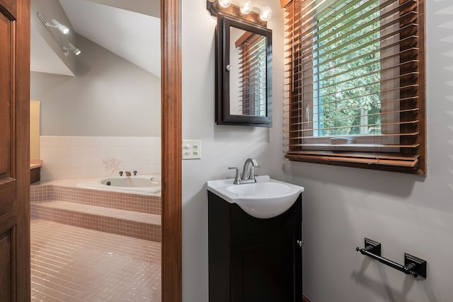 bathroom featuring vanity and tiled tub