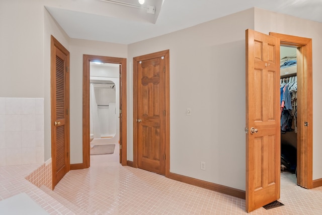 tiled bedroom featuring ensuite bathroom and a closet