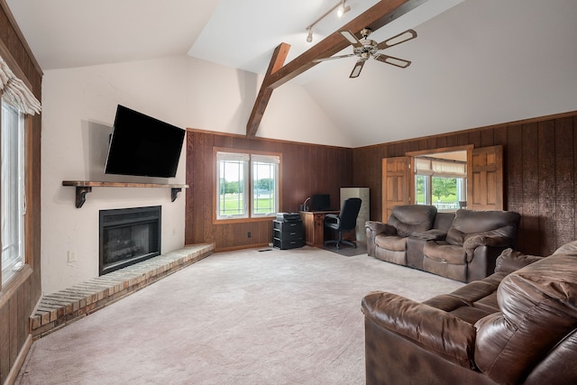 living room with a fireplace, lofted ceiling with beams, ceiling fan, and wooden walls