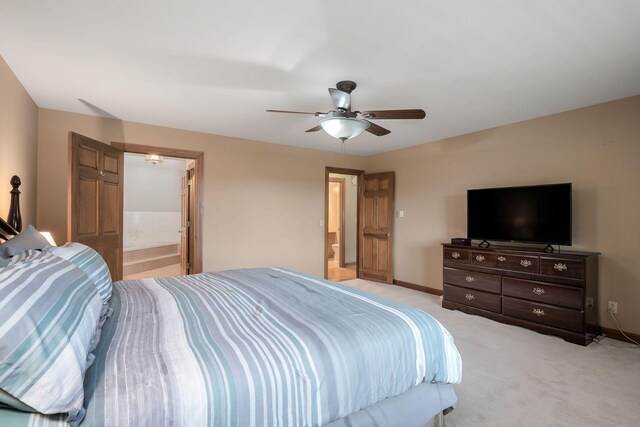 bedroom with light carpet, ensuite bathroom, and ceiling fan