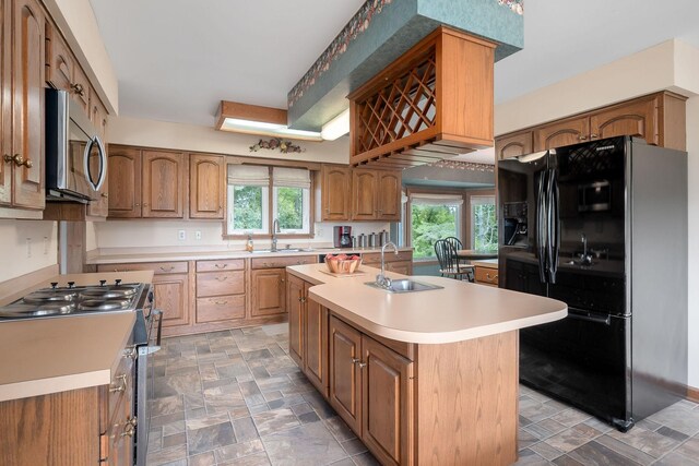 kitchen featuring stainless steel appliances, a center island with sink, and sink