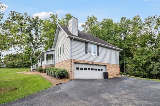 view of side of property featuring a yard, a garage, and a porch