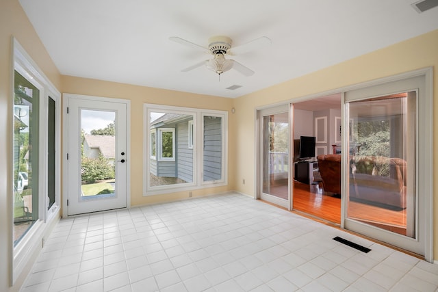 unfurnished sunroom featuring ceiling fan