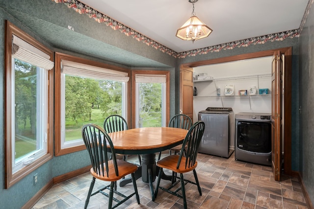 dining room featuring a healthy amount of sunlight, washing machine and clothes dryer, and a notable chandelier