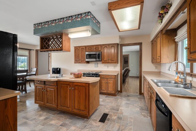 kitchen with black appliances, a center island, and sink