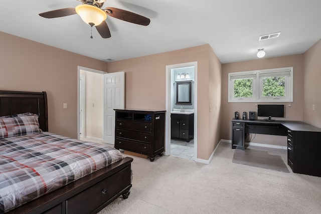 carpeted bedroom with ceiling fan, sink, and ensuite bath