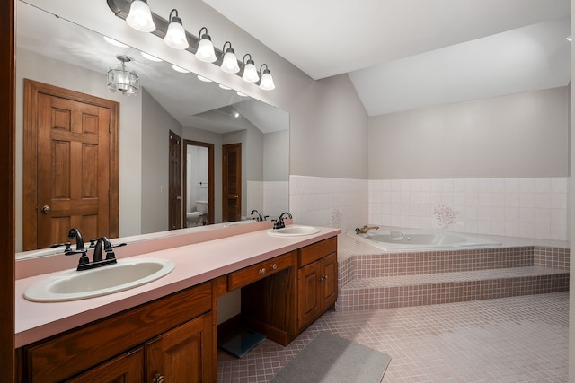 bathroom featuring vanity, tiled bath, tile patterned flooring, toilet, and lofted ceiling