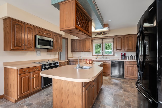 kitchen with black appliances, an island with sink, and sink