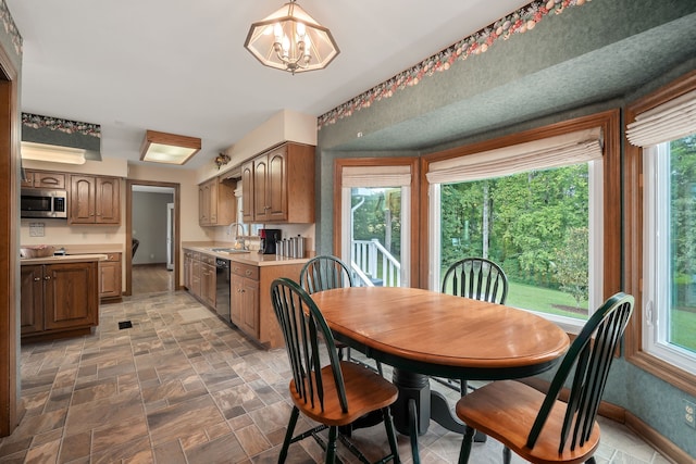 dining room with a healthy amount of sunlight, a chandelier, and sink