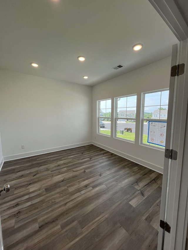 spare room with baseboards, recessed lighting, and dark wood finished floors