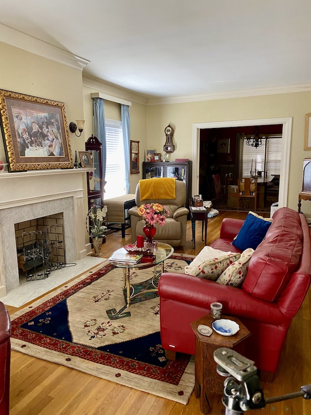 living room featuring crown molding, a fireplace, and hardwood / wood-style floors