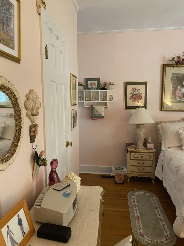 bedroom with ornamental molding and hardwood / wood-style flooring