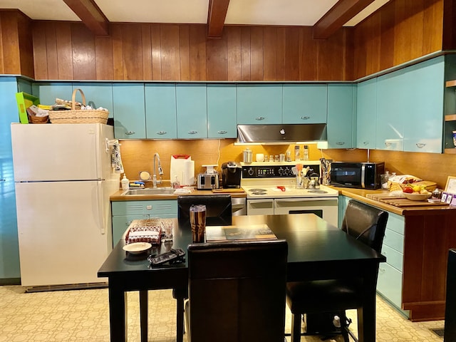 kitchen with sink, beam ceiling, and white appliances