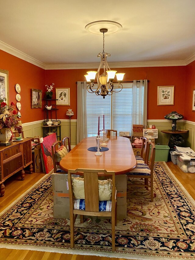 dining space with ornamental molding, light hardwood / wood-style flooring, and a chandelier