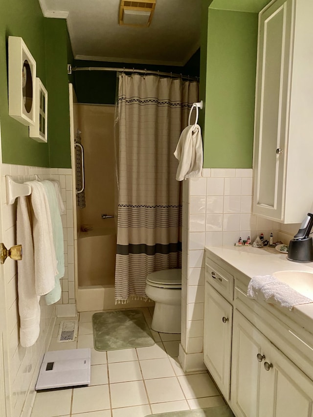 bathroom with tile walls, curtained shower, vanity, tile patterned flooring, and toilet