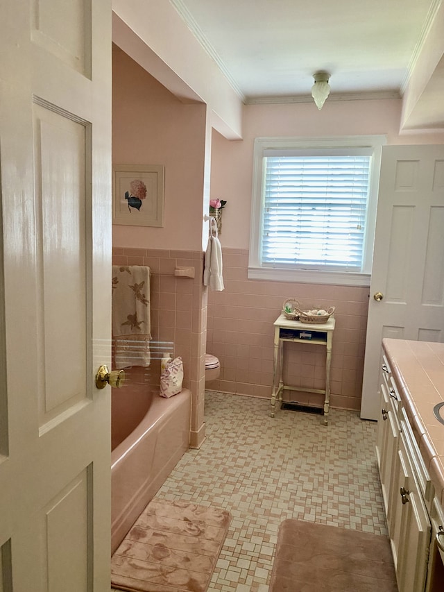 bathroom with vanity, a tub to relax in, tile walls, crown molding, and toilet