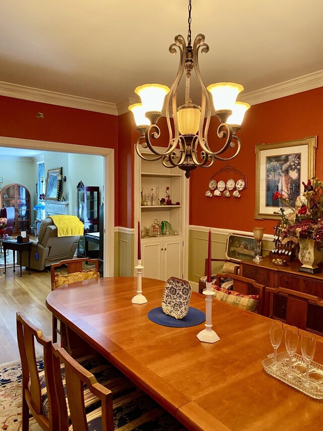 dining room featuring a notable chandelier, hardwood / wood-style flooring, and ornamental molding