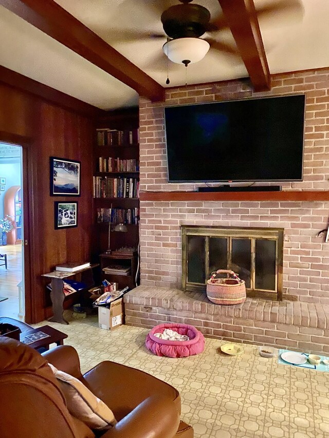 living room featuring a brick fireplace and beam ceiling