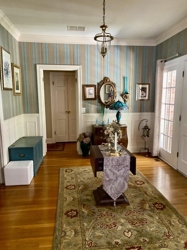 sitting room featuring wood-type flooring and crown molding