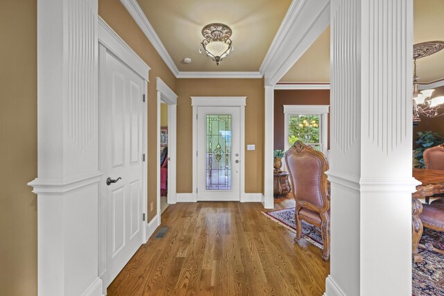 foyer featuring ornamental molding, hardwood / wood-style floors, and an inviting chandelier