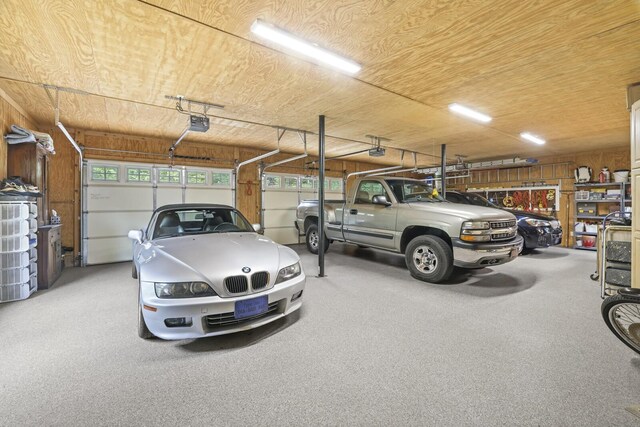 garage featuring wood walls and a garage door opener