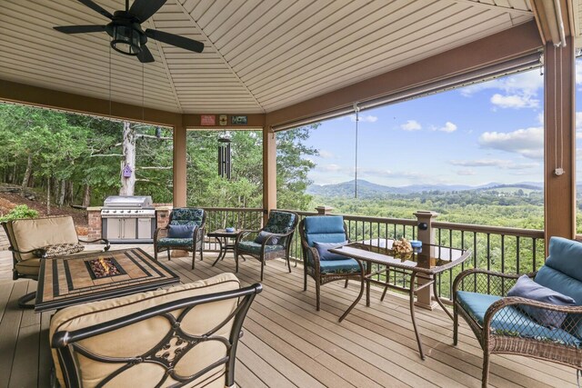 sunroom with a mountain view, vaulted ceiling, and ceiling fan