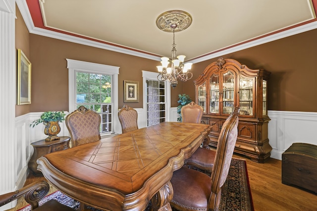 dining space with hardwood / wood-style floors, a chandelier, and ornamental molding