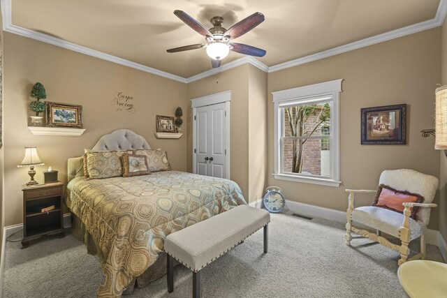 bedroom featuring ornamental molding, a closet, ceiling fan, and carpet floors