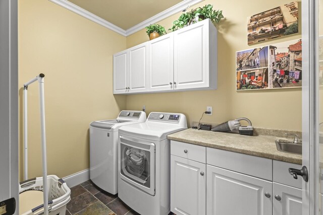 washroom with washing machine and clothes dryer, cabinets, and ornamental molding