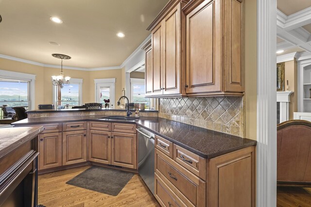 kitchen with light wood-type flooring, stainless steel dishwasher, sink, and a notable chandelier