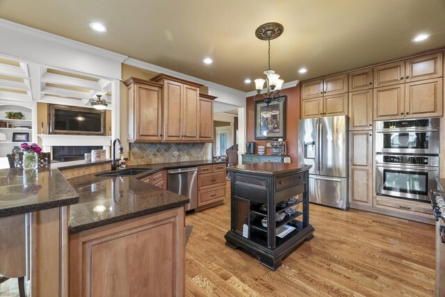 kitchen featuring ornamental molding, light hardwood / wood-style flooring, stainless steel appliances, an inviting chandelier, and sink