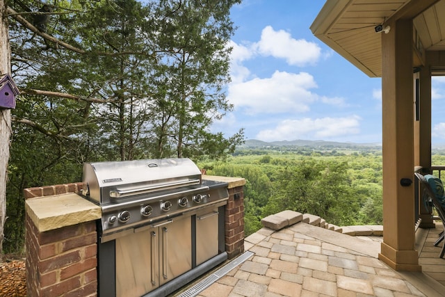 view of patio / terrace with a mountain view, area for grilling, and a grill